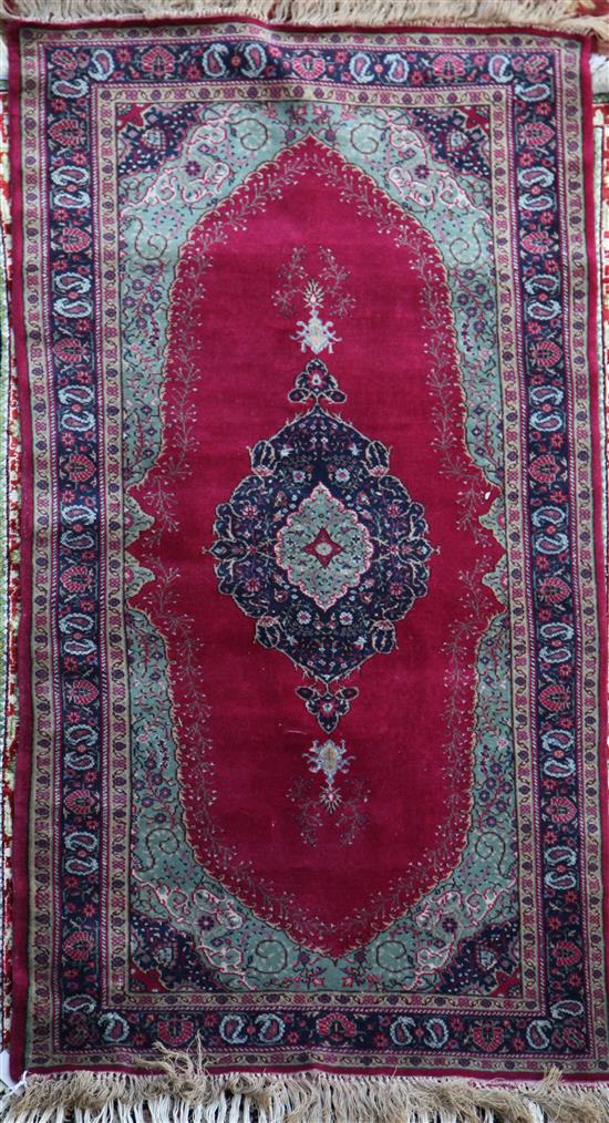 A Sparta style red and green ground rug, 5ft 8in by 3ft 1in.